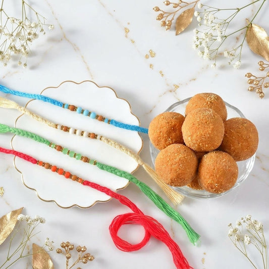 Vibrant Hand-Braided Rakhi Quad with Festive Besan Laddu Box