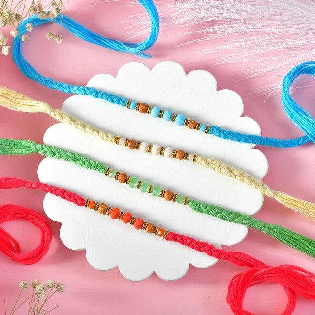 Vibrant Hand-Braided Rakhi Quad with Festive Besan Laddu Box